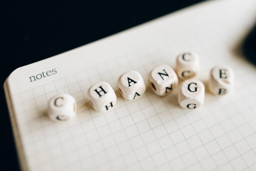 pexels photo 6120220 Close-up of letter dice spelling 'change' on a grid notepad, symbolizing transformation.